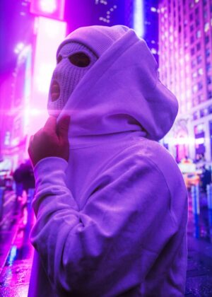 Neon City Nights: Mysterious Figure in White Hood - Premium Wooden Framed Poster. Ready to Hang.